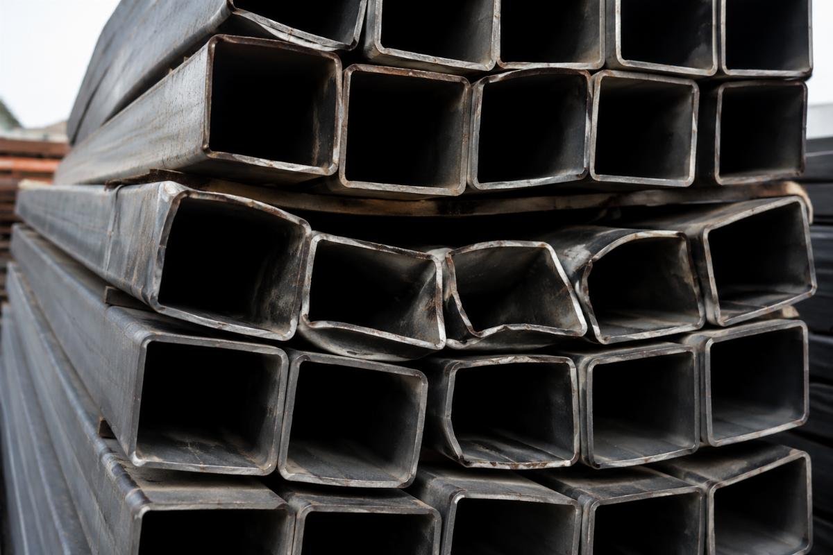 Close-up view of deformed square hollow sections due to improper stacking and lack of dunnage